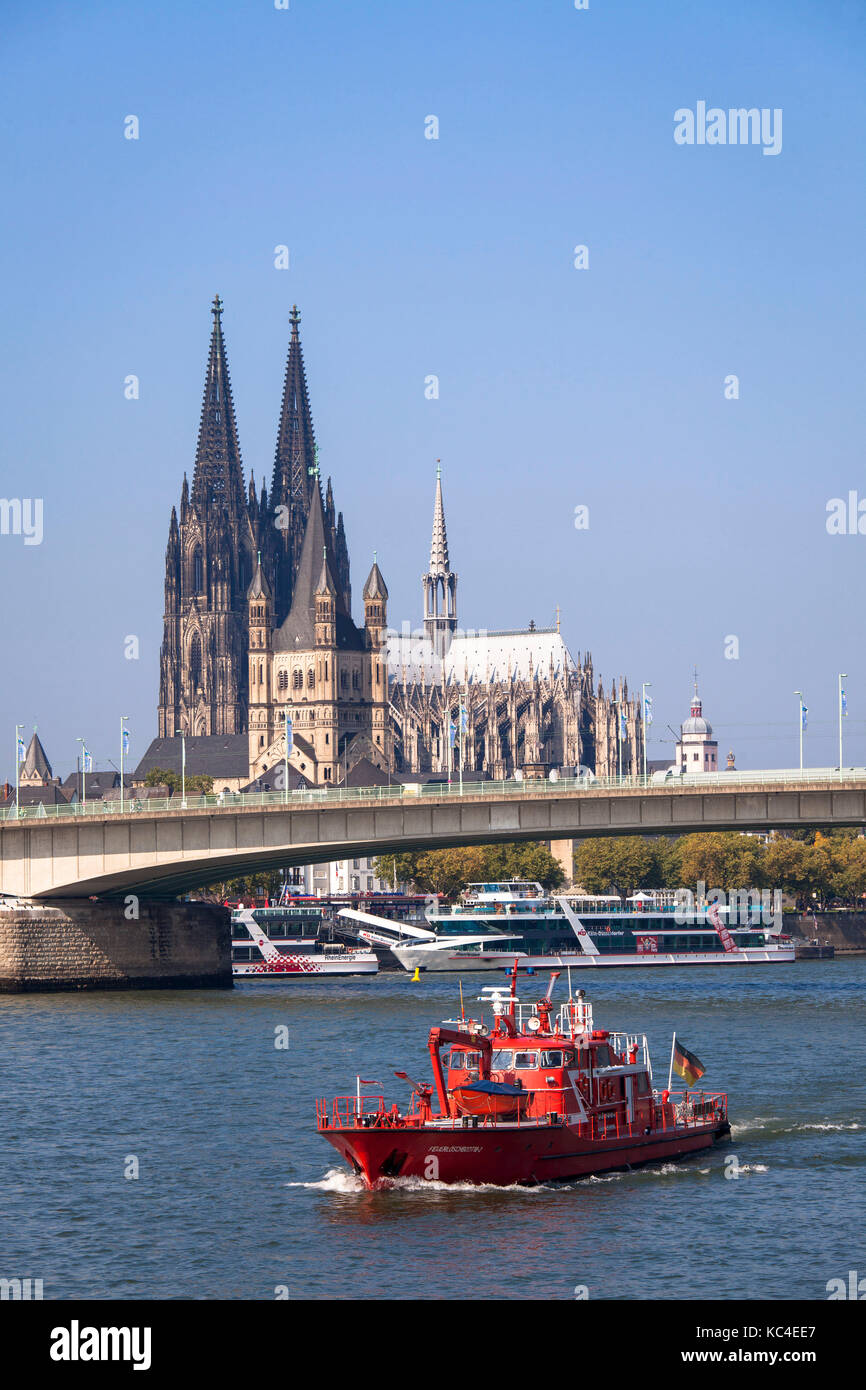 Germania, Colonia, una barca antincendio sul fiume Reno di fronte alla cattedrale e la chiesa Gross St. Martin. Deutschland, Koeln, ein Feuerlo Foto Stock