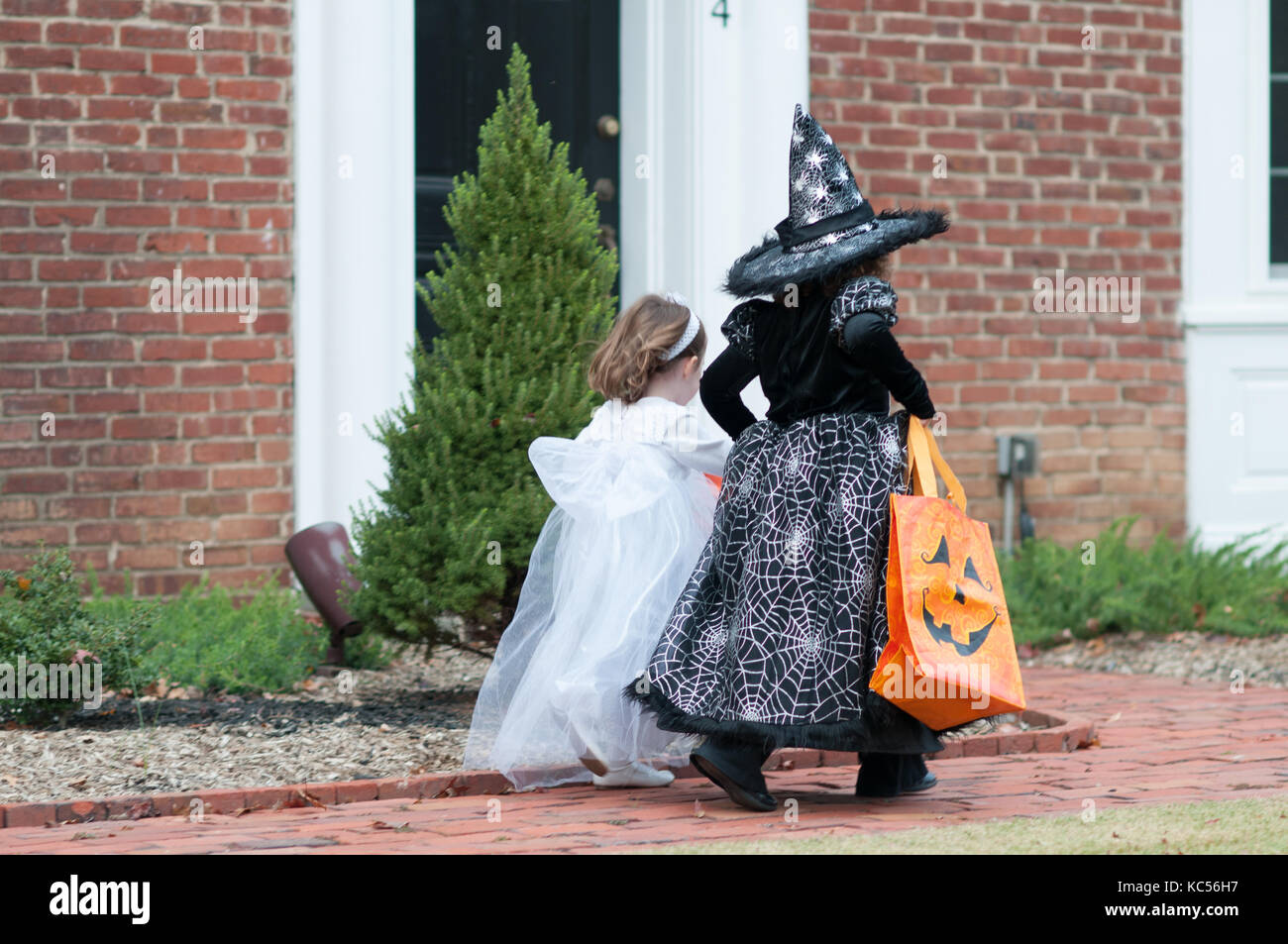 Vista delle bambine in strega e costume fantasma avente il divertimento di  halloween dolcetto o scherzetto Foto stock - Alamy