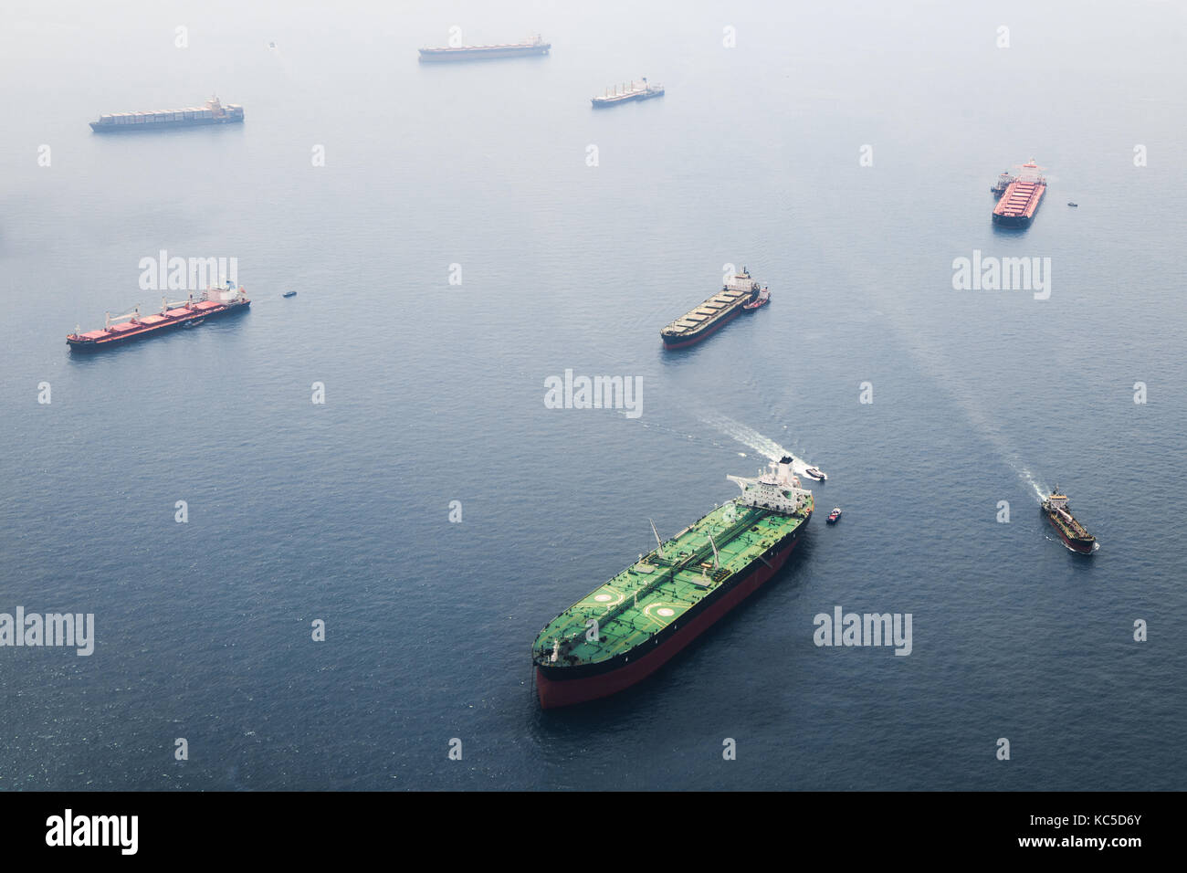 Le navi in stretto di Singapore dalla altezza. Grande cisterna con due piattaforme in elicottero rimanere sul dispositivo di ancoraggio e di attendere il loro turno per immettere la porta per u Foto Stock