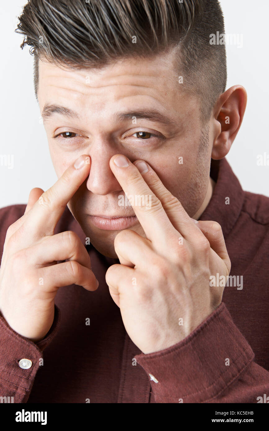 Studio shot dell uomo che soffre con problema sinusale Foto Stock