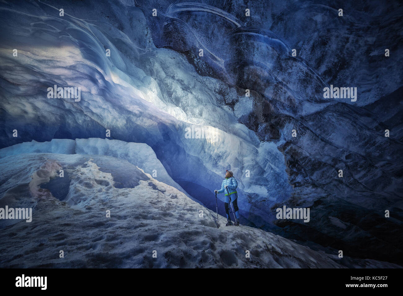 Explorer ragazza all'interno di una caverna di ghiaccio durante una spedizione di fotografia in Ghiacciaio Athabasca Foto Stock