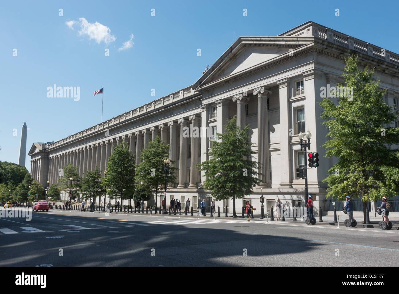 U.s. Treasury Department building, Washington DC. il Washington Monument inbackground, segway turisti, troppo. Xv sul lato della strada. Foto Stock