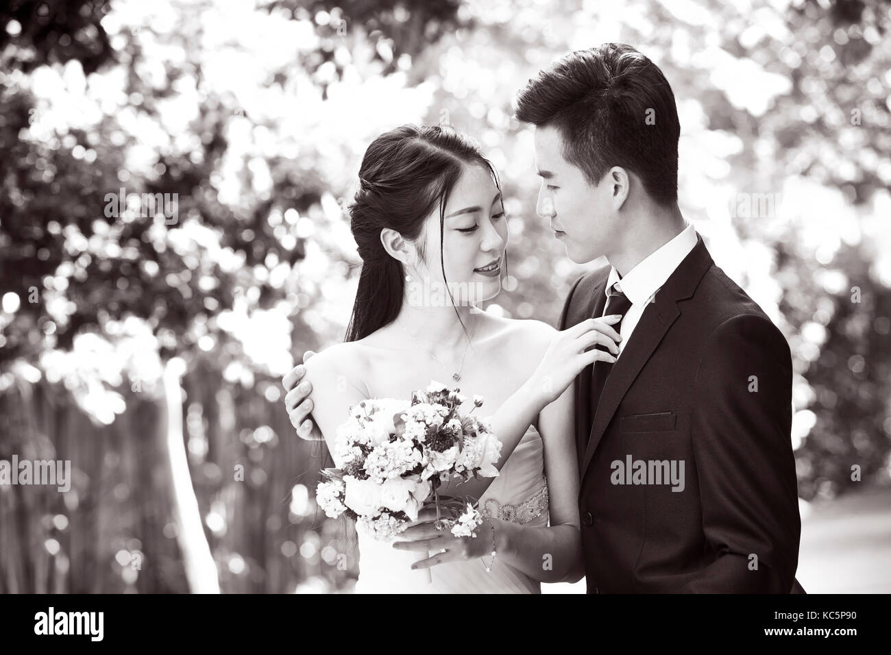 Outdoor ritratto di asian sposa e lo sposo, felice e sorridente, in bianco e nero. Foto Stock