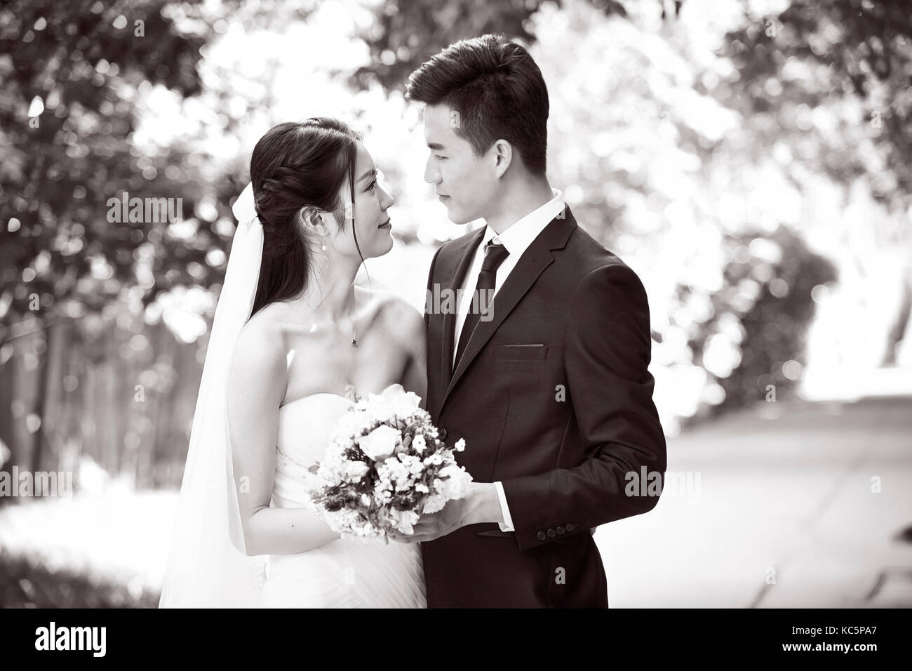 Outdoor ritratto di asian sposa e lo sposo, felice e sorridente, in bianco e nero. Foto Stock