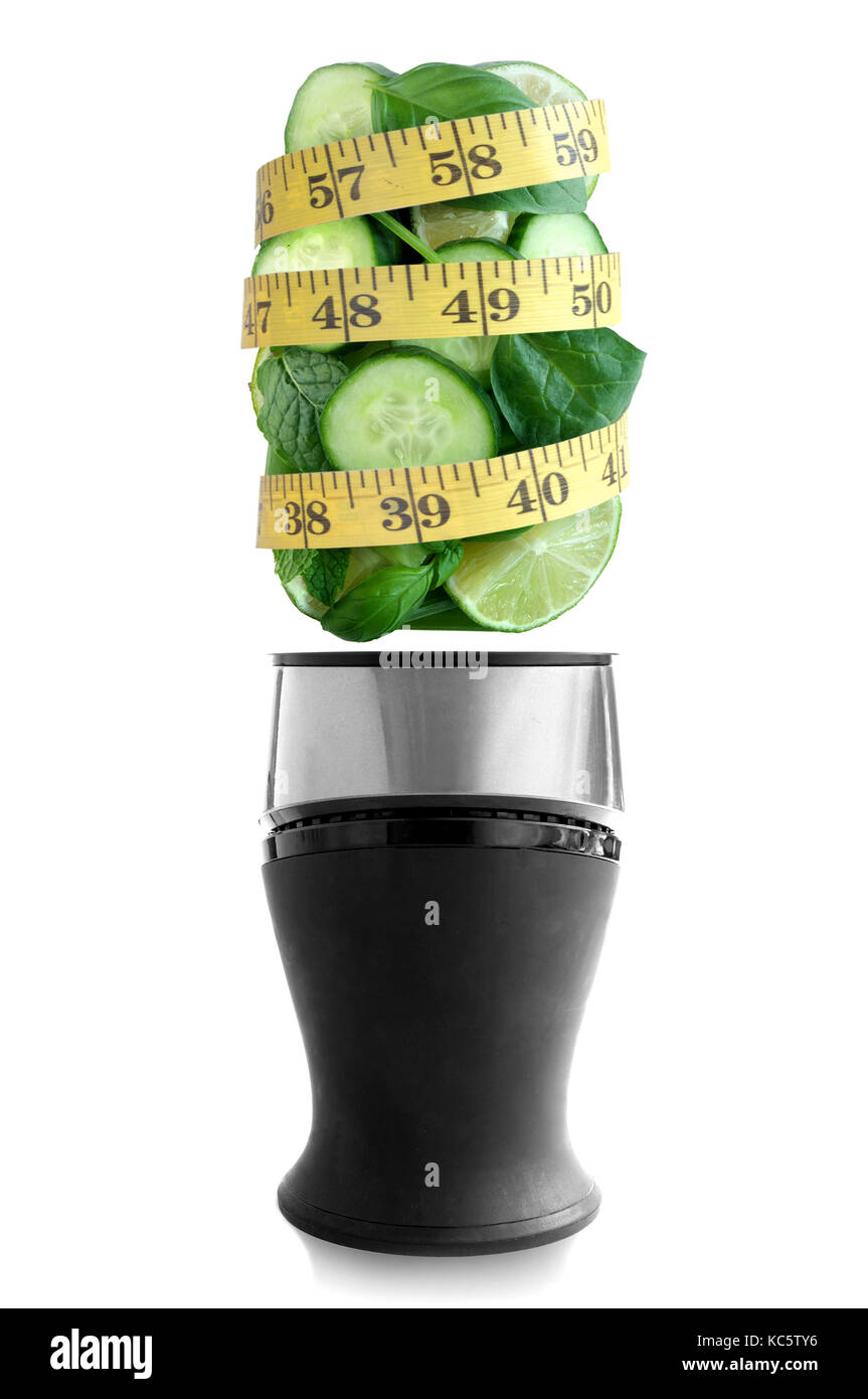 Verde fresco frutta e verdura al di sopra di un frullatore con nastro di misurazione Foto Stock