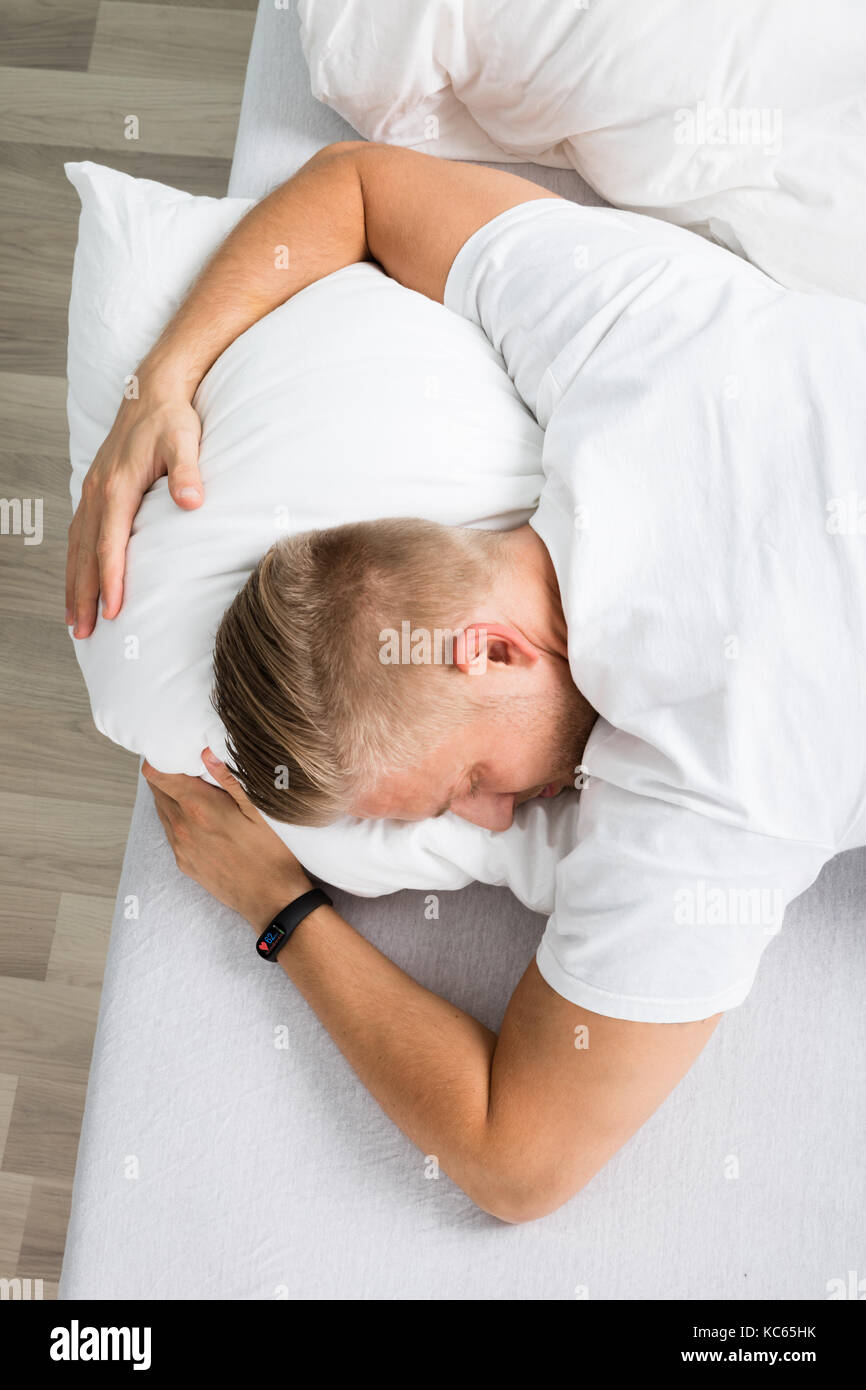 Vista in elevazione di un uomo che dorme sul letto Foto Stock