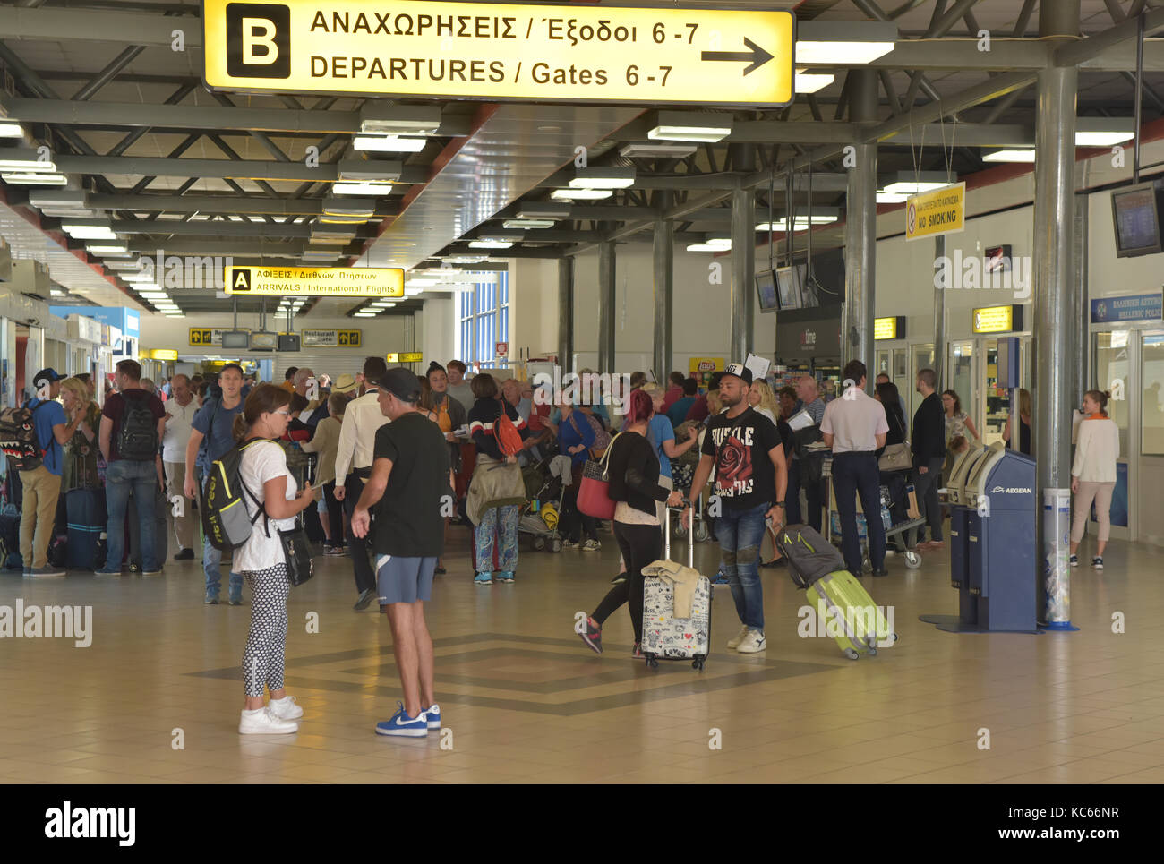 La sala principale o arrivi e partenze hall all aeroporto di Corfu in Grecia è occupata con i vacanzieri in arrivo e in attesa di voli in e out pianificato. Foto Stock