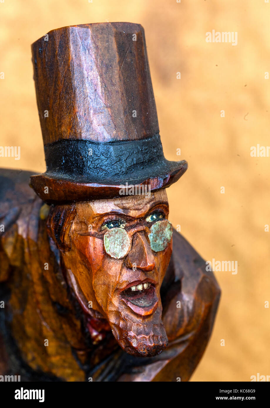 Antiche sculture in legno di angry man in top hat con gli occhiali Foto Stock