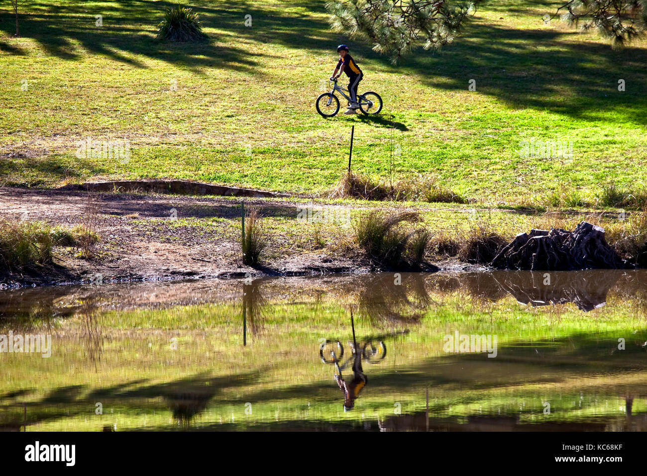 Ciclista a cavallo lungo la riva del lago Burley Griffin a Canberra, della capitale nazionale dell'australia Foto Stock