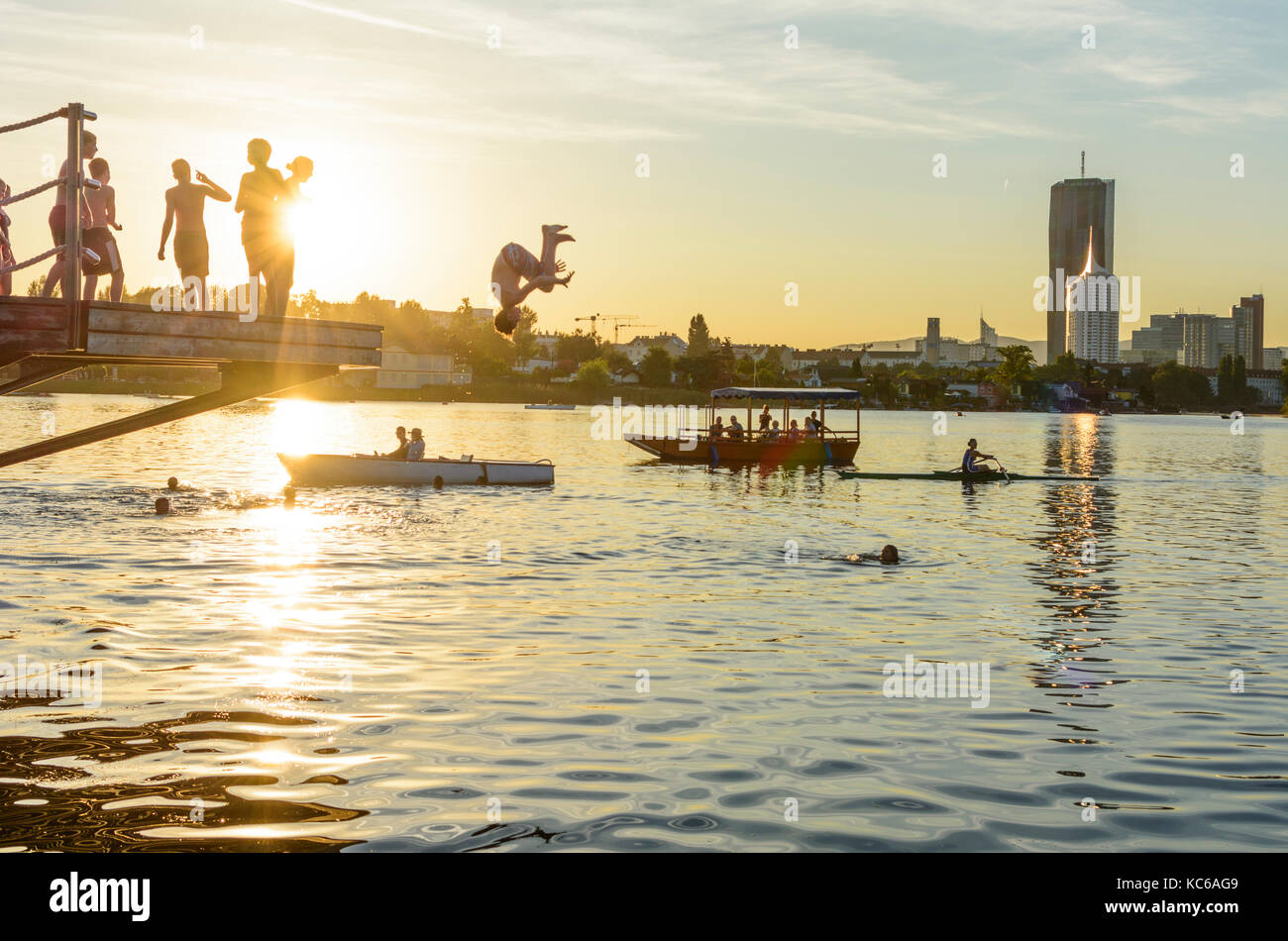 Bambini, bambini saltare in acqua, fiume Alte Donau (Vecchio Danubio), skyline di Donaucity, DC Tower 1, barche, Wien, Vienna, 22. Donaustadt, Wien, Austria Foto Stock