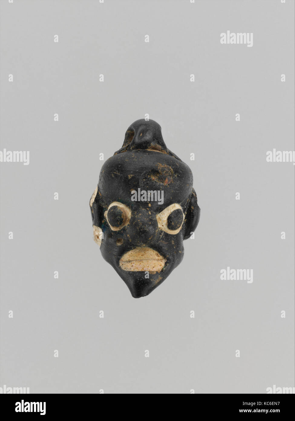 Pendente in vetro sotto forma di una maschera demoniaca, metà-5A-IV secolo A.C. Foto Stock
