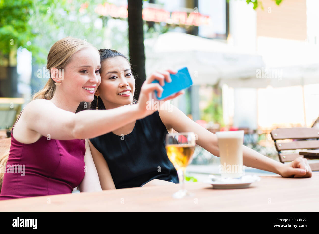 Giovani moda donna prendendo selfie con telefono in cafe Foto Stock