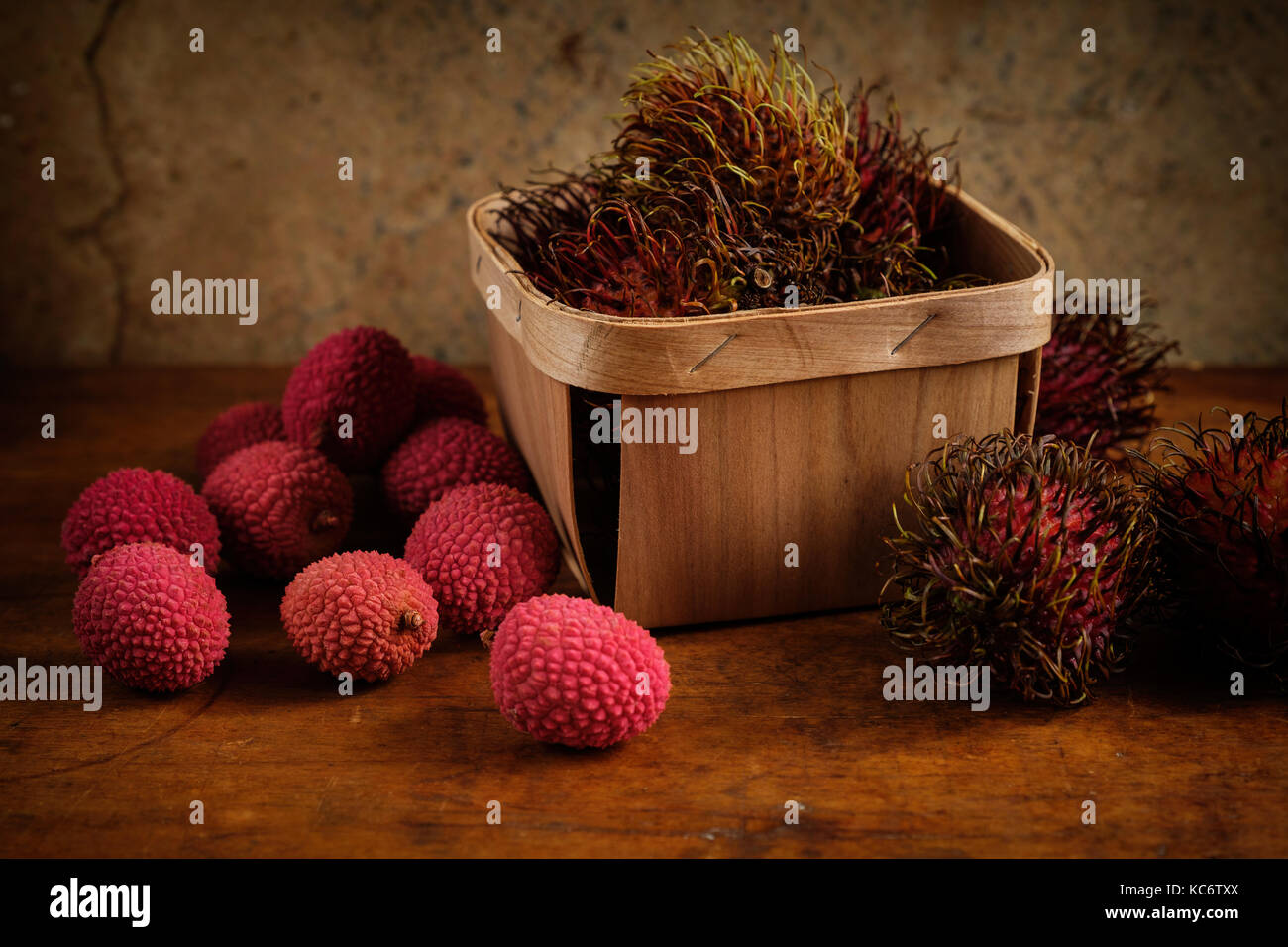 Il lychee organico nel cestello e sul tavolo di legno Foto Stock