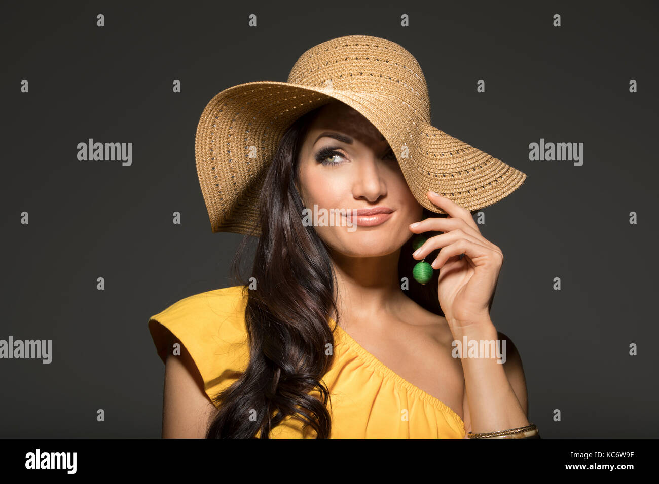 Ritratto di donna che indossa cappello di paglia e giallo in alto Foto Stock
