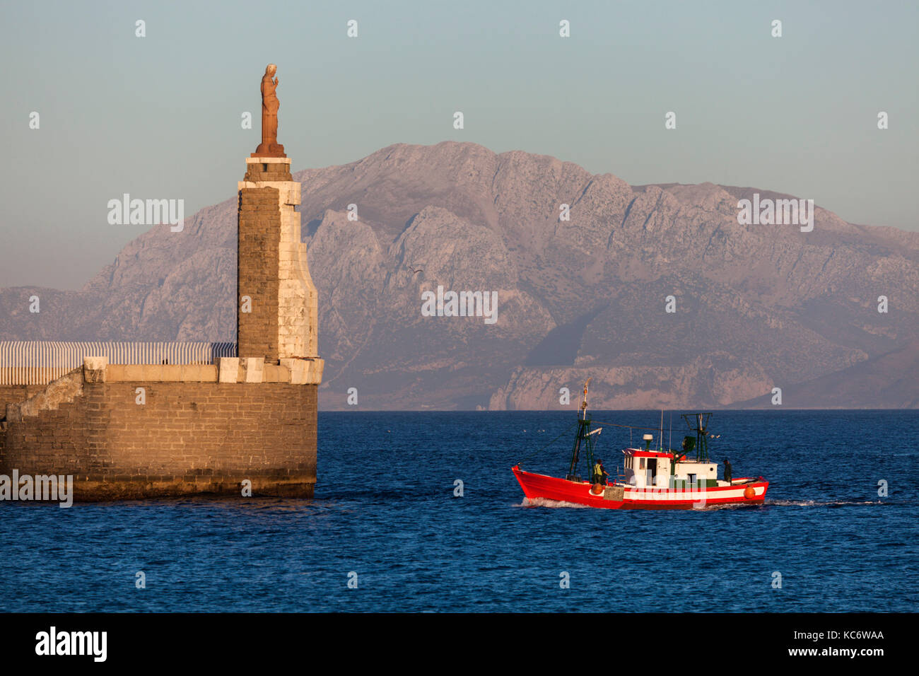 Spagna, Andalusia, Tarifa, porto di Tarifa, Gesù Cristo statua dal mare rosso e la pesca in barca Foto Stock