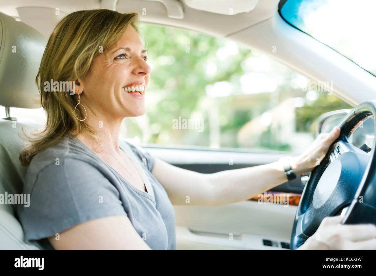 Donna sorridente auto pilotaggio Foto Stock