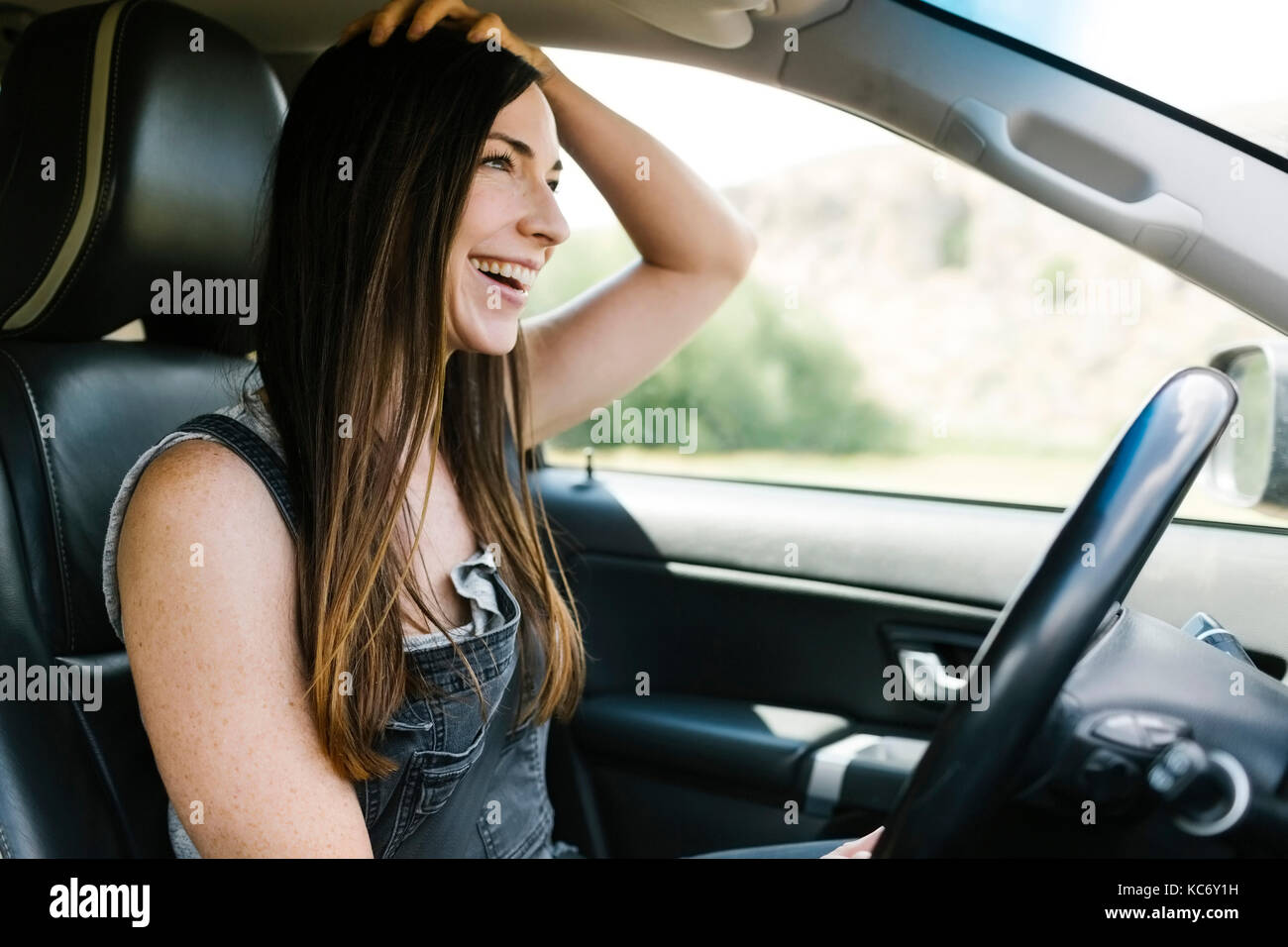 Donna sorridente auto pilotaggio Foto Stock