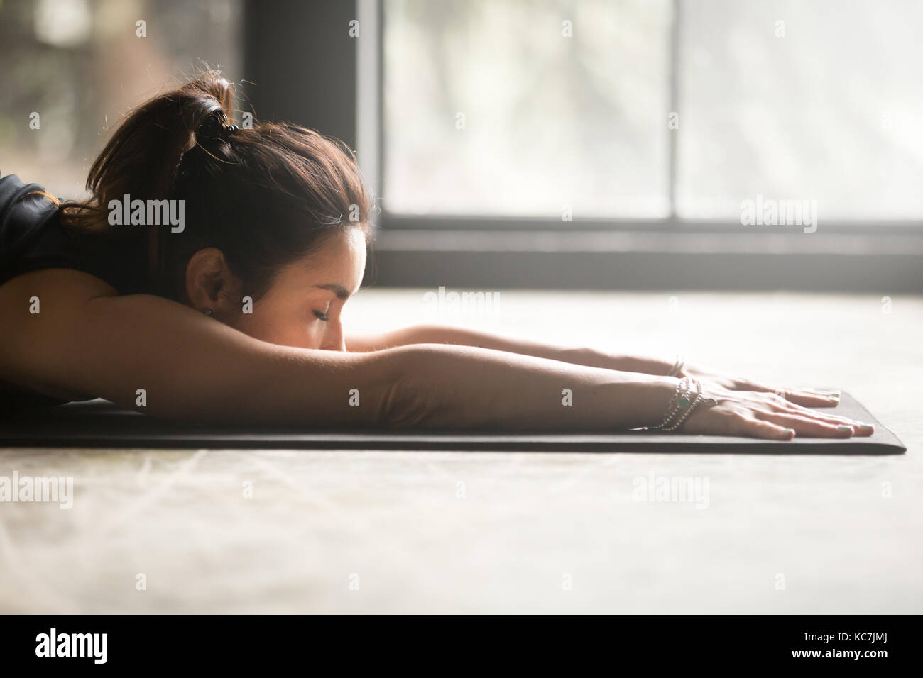 Giovane donna attraente stretching sul pavimento Foto Stock