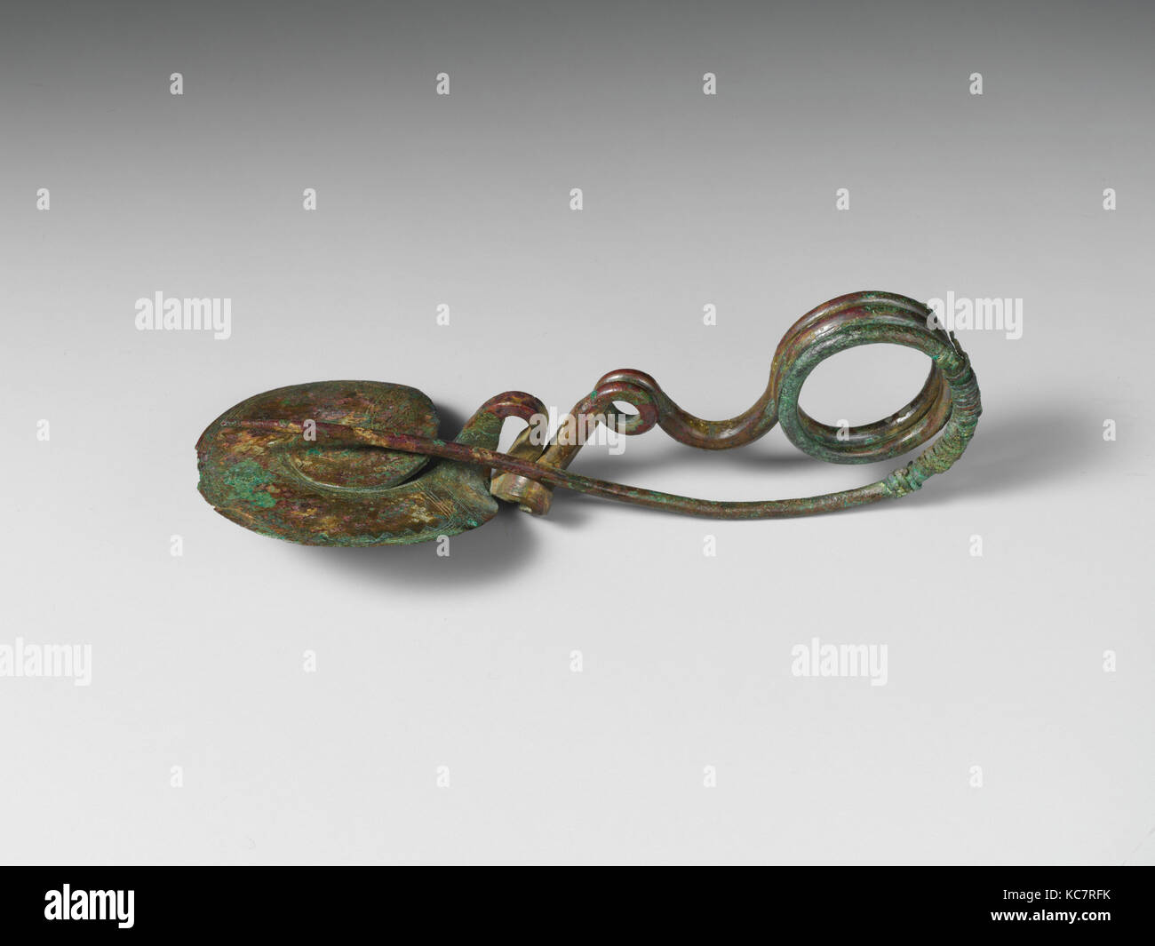 Serpentina di bronzo-tipo di disco fibula (perno di sicurezza), IX secolo A.C. Foto Stock