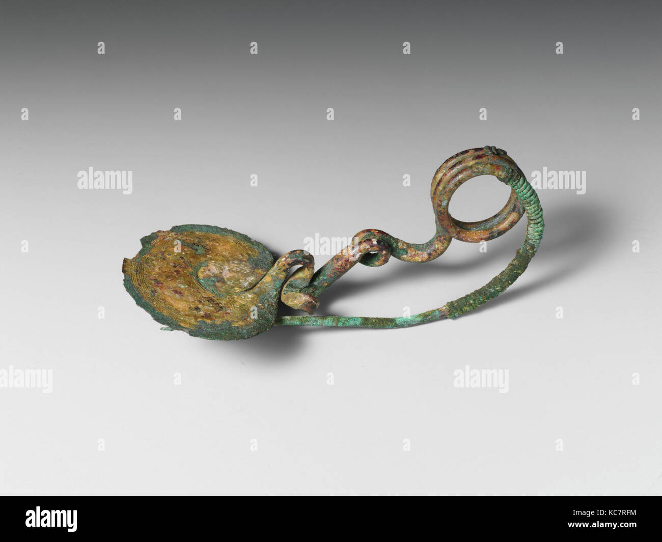 Serpentina di bronzo-tipo di disco fibula (perno di sicurezza), IX secolo A.C. Foto Stock