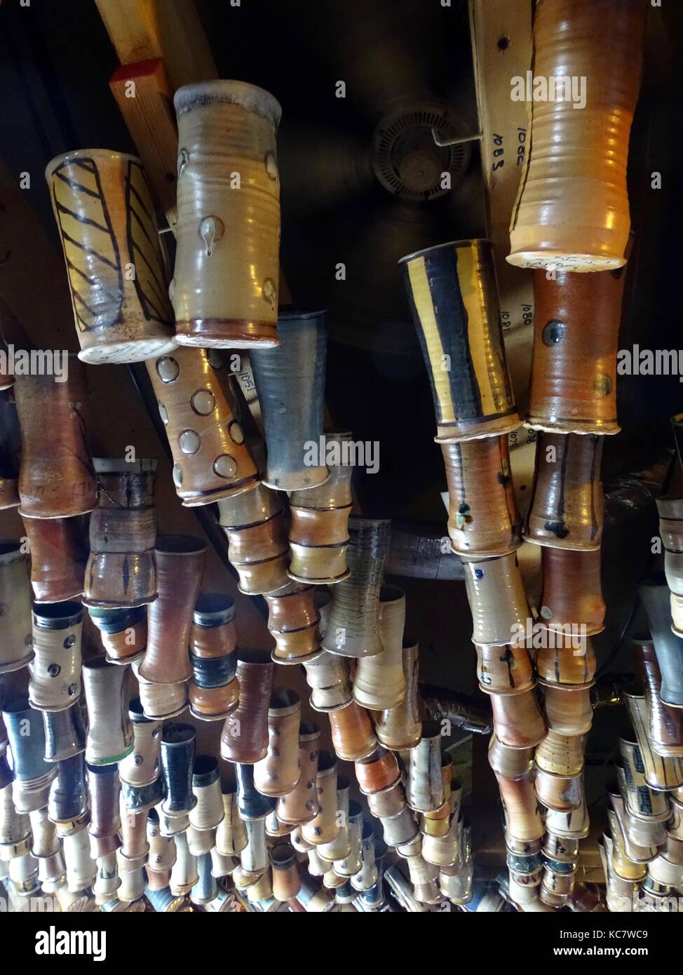 Una grande quantità di tazze di ceramica appeso ad un soffitto in un pub locale Foto Stock