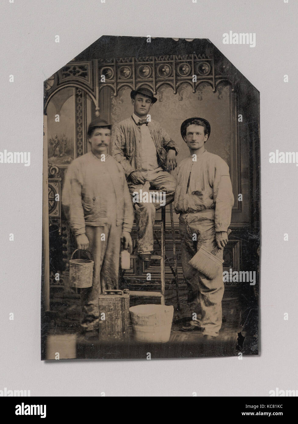 Tre pittori, disposti su e intorno a una scaletta, con spazzole, benna e la vernice può, sconosciuto, 1870s-80s Foto Stock