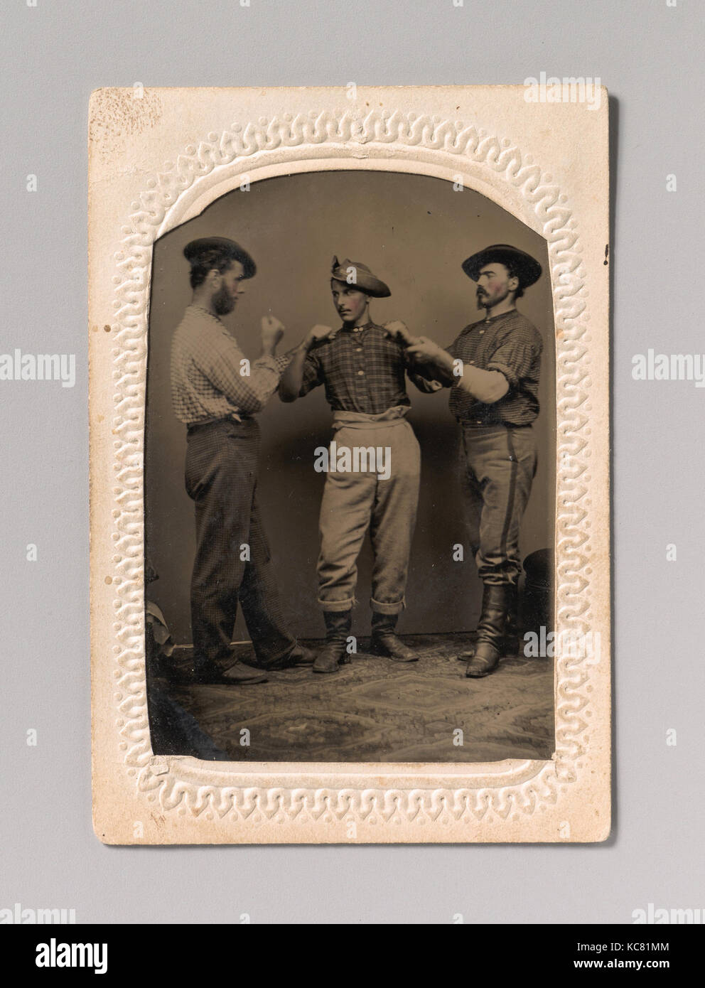 Due uomini in atteggiamento di inscatolamento, un terzo uomo la regolazione di un uomo di forma, J. C. Batchelder, 1860s-80s Foto Stock