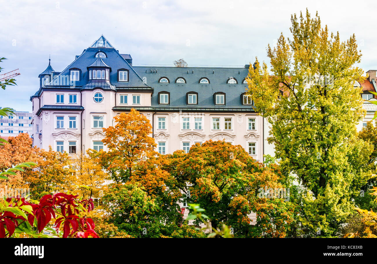 Vista sulla storica edificio residenziale prima colorfull alberi in autunno nella città di Monaco di Baviera Foto Stock