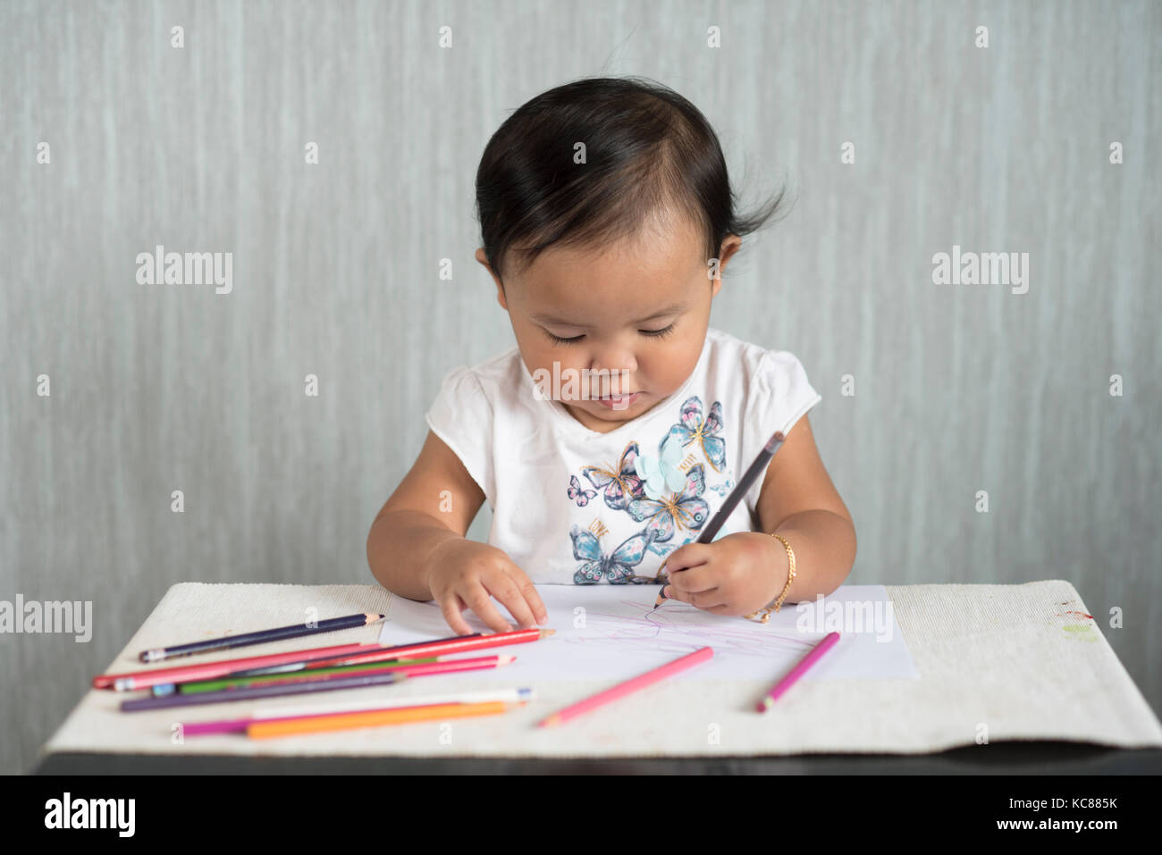 Asian toddler / bambina è divertirsi imparando a usare matite. Il concetto di istruzione. la crescita umana del concetto. Foto Stock