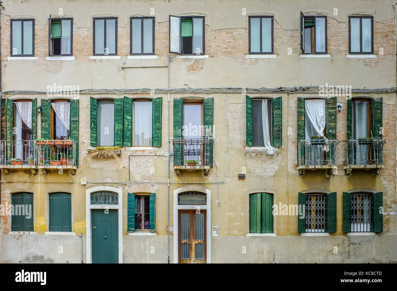 Un tipico canale veneziano-edificio laterale con persiane verdi Foto Stock