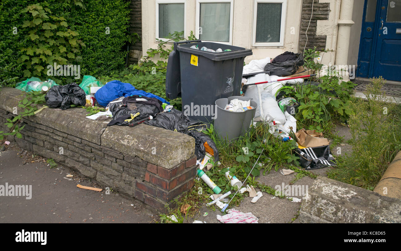 La spazzatura in attesa di raccolta a fine anno accademico dal giardino della casa precedentemente occupato da studenti, Cardiff, Regno Unito Foto Stock