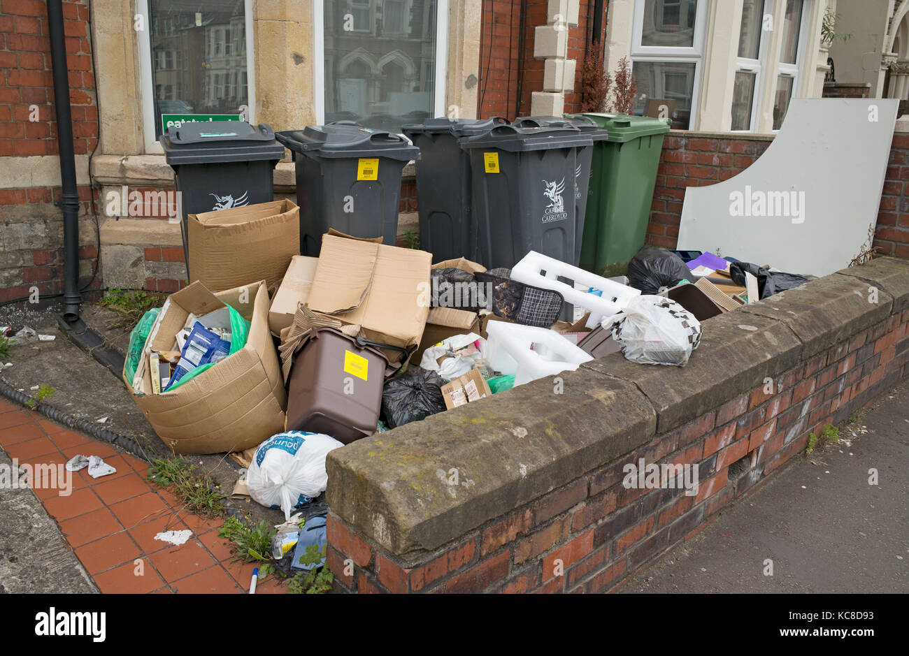 La spazzatura in attesa di raccolta a fine anno accademico dal giardino della casa precedentemente occupato da studenti, Cardiff, Regno Unito Foto Stock