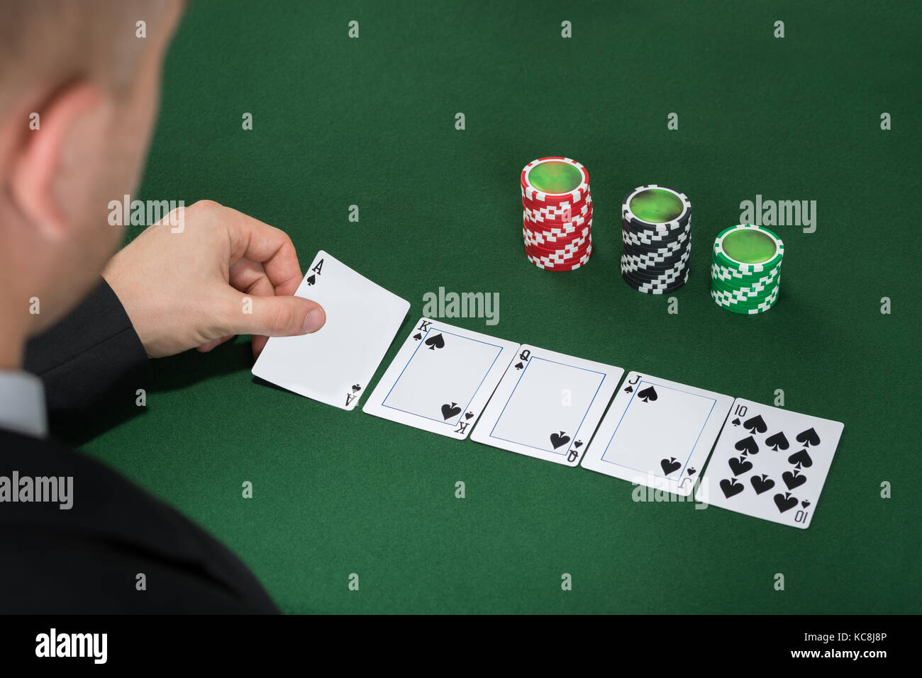 Close-up del giocatore di poker giocando a carte sul tavolo verde Foto Stock