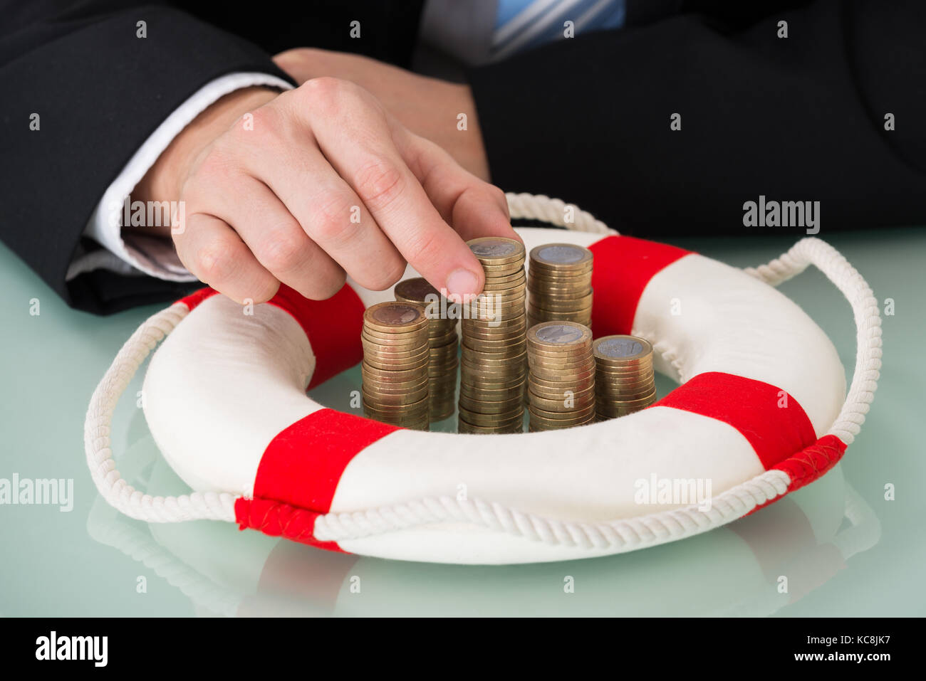 Close-up di persona in possesso di bottone impilato circondato da Lifebelt Foto Stock