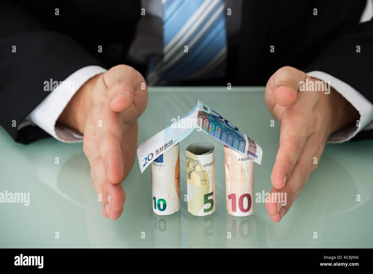 Close-up di un imprenditore proteggere casa fatta di banconote Foto Stock