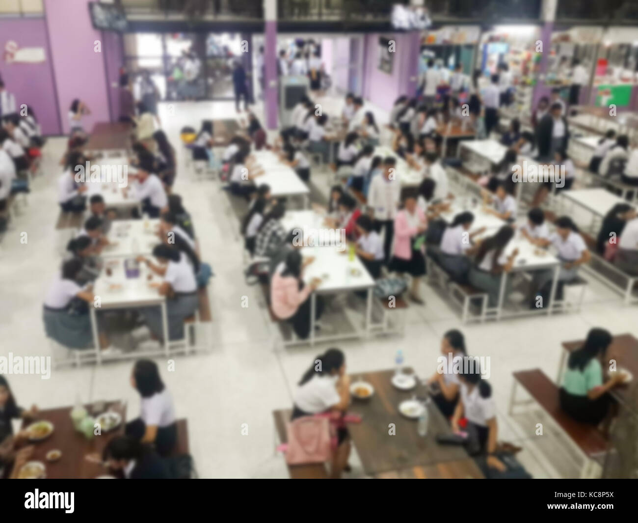 Immagine della sfuocatura mensa sala da pranzo Camera, un sacco di persone che vengono a mangiare cibo in mensa universitaria blur sullo sfondo Foto Stock