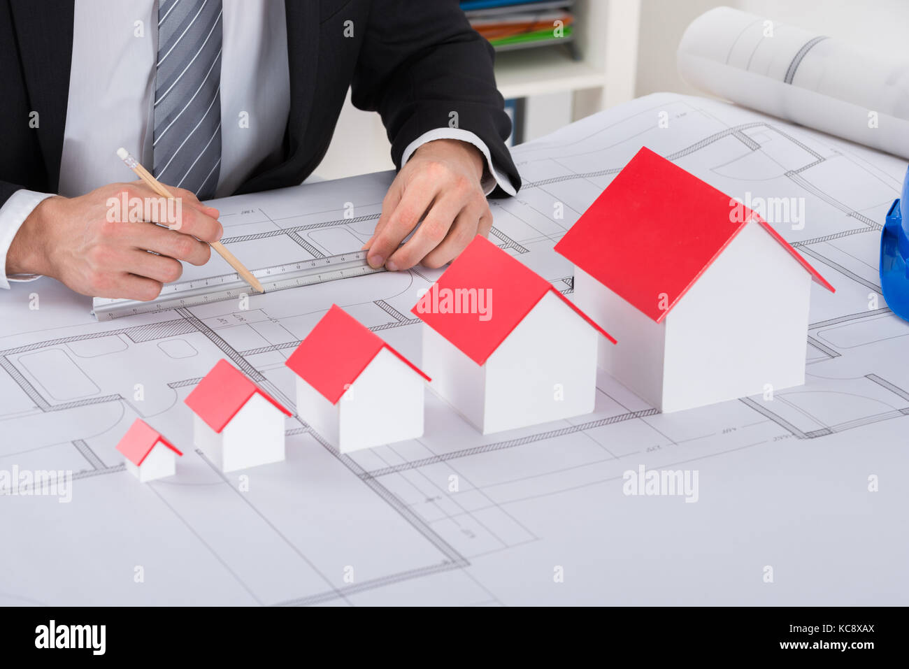 Close-up di architetto maschio mano con modelli della casa a lavorare sul progetto in ufficio Foto Stock