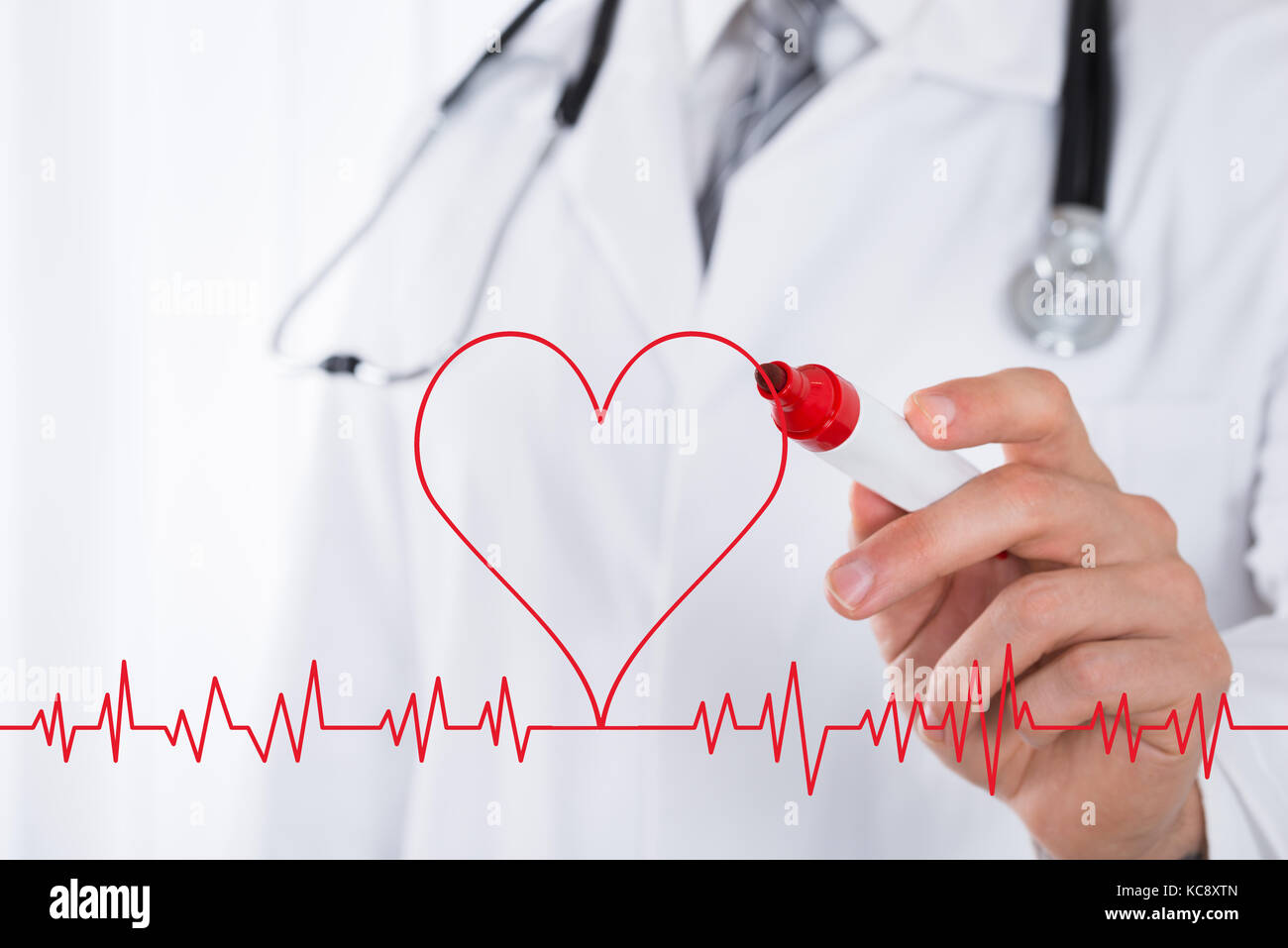 Close-up del medico maschio del disegno a mano un simbolo del cuore nei pressi di elettrocardiogramma con indicatore rosso Foto Stock