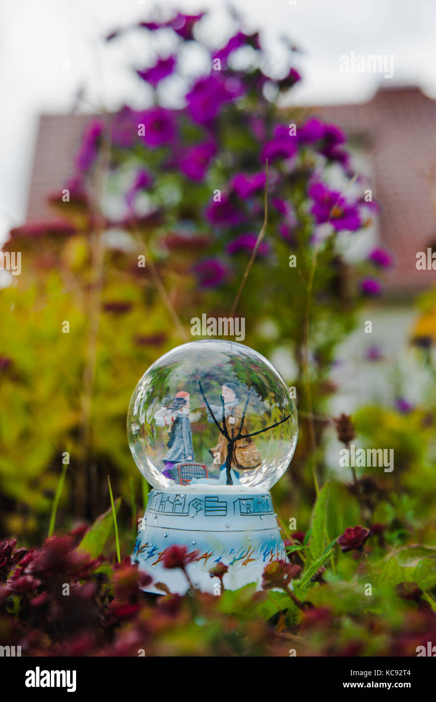 Toy matura in un globo di vetro nella parte anteriore dei fiori Foto Stock