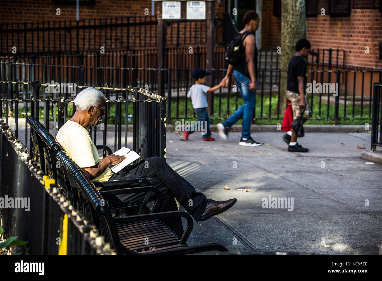 La lettura della Bibbia in basso reddito alloggiamento, East Village di New York City Foto Stock