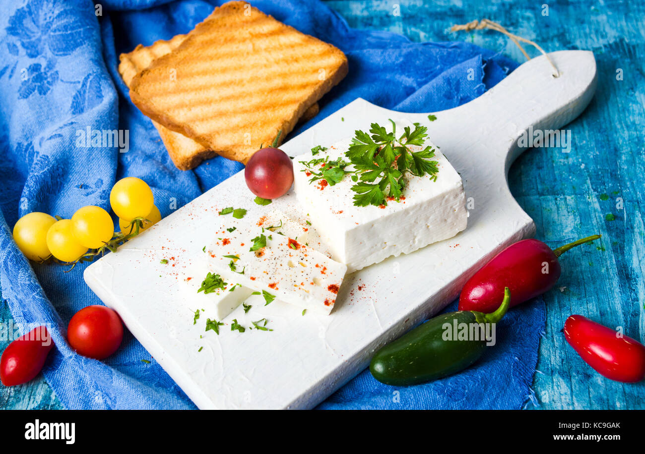 Panino al formaggio, di ingredienti vegetali su un tagliere Foto Stock