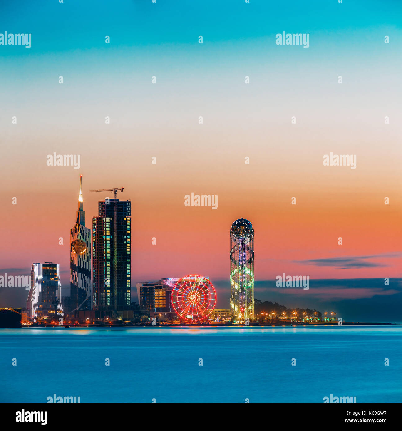 Batumi, adjara, Georgia. scena della cittadina al tramonto o l'alba. luminose del cielo della sera in giallo, arancione e viola i colori. vista dal mare spiaggia a ill Foto Stock