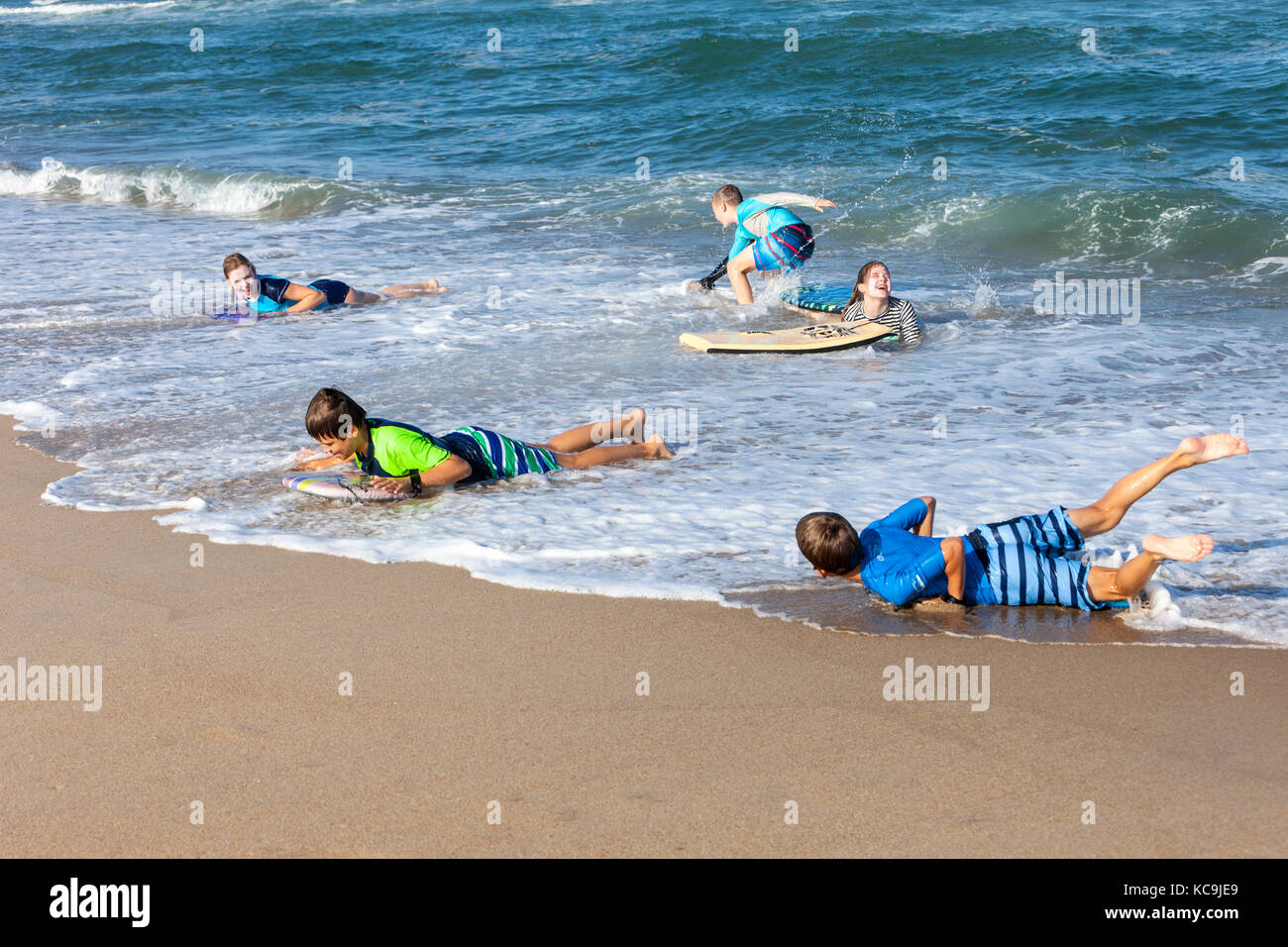 Avon, Outer Banks, North Carolina, Stati Uniti d'America. Bambini che giocano su tavole boogie in Atlantico Surf. Foto Stock