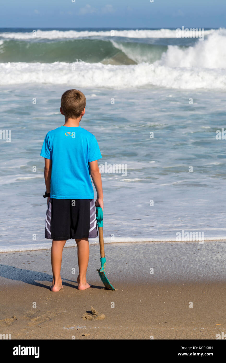 Avon, Outer Banks, North Carolina, Stati Uniti d'America. Ragazzo giovane contemplando la Atlantic Waves. Foto Stock