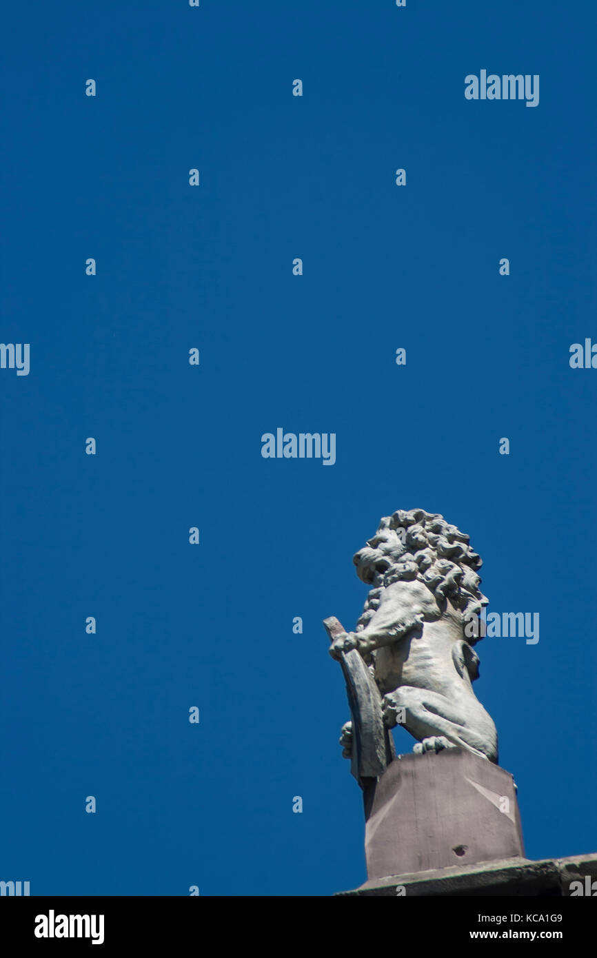 Una statua di lion infron di cielo blu Foto Stock