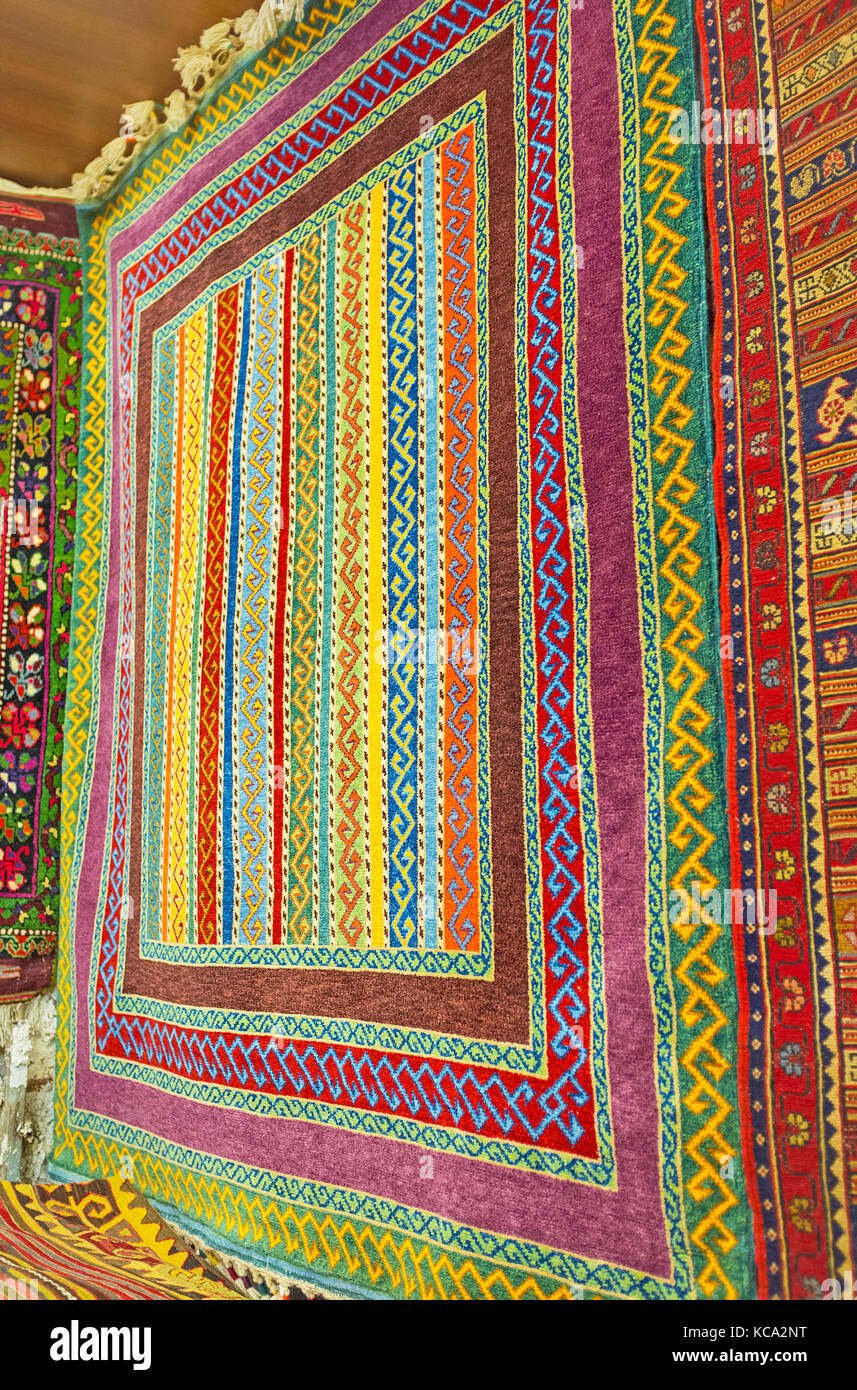 La parete colorato tappeto nella vetrina del negozio è coperto con il primitivo disegno geometrico in stile tradizionale, Antalya vecchio bazaar, Turchia. Foto Stock