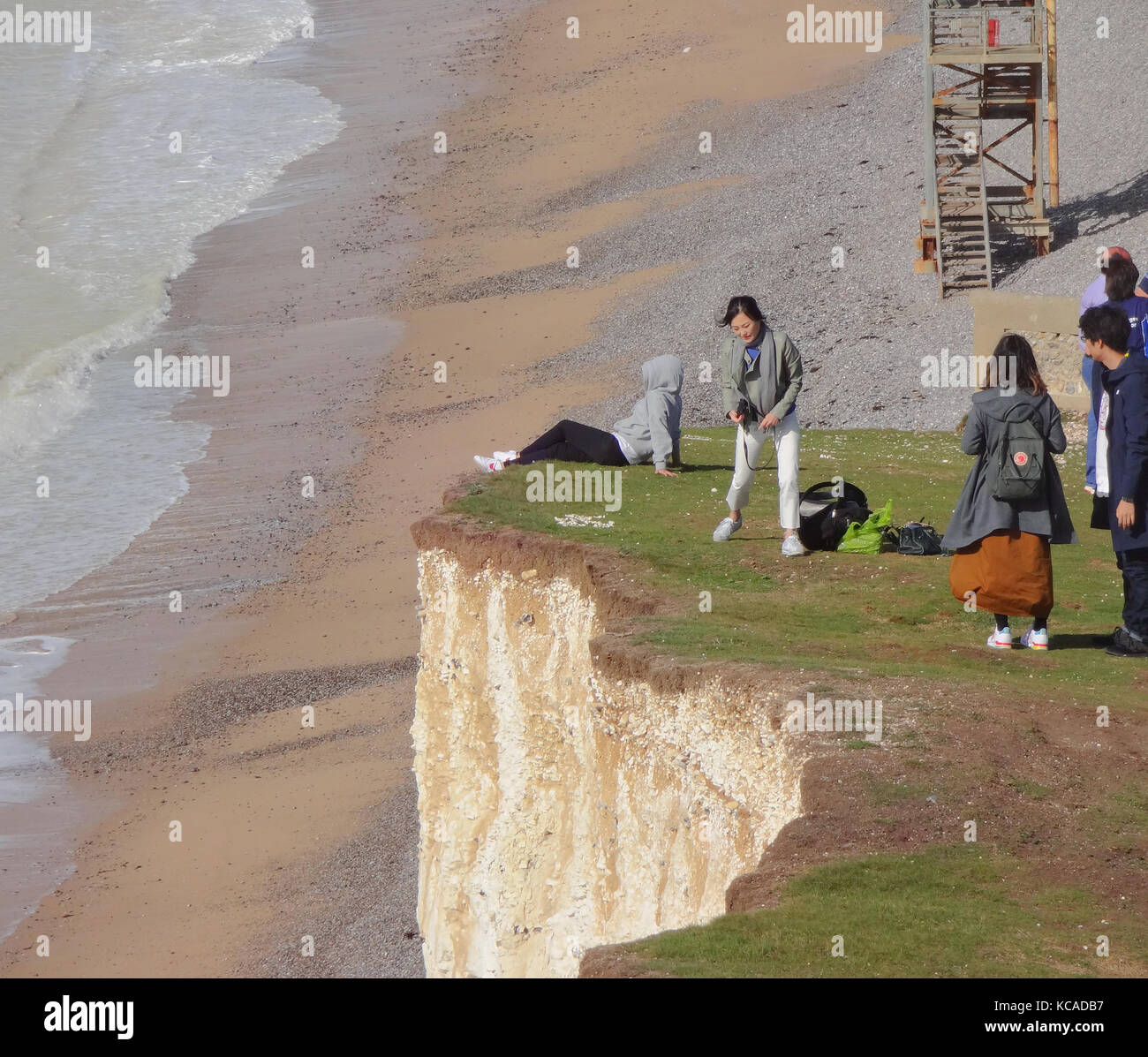 Birling Gap, Eastbourne, East Sussex, Regno Unito 3 ottobre 2017..L'erosione Accelerata delle scogliere calcaree nel punto di bellezza South Downs National Trust ha portato avanti lavori essenziali per i gradini di accesso alla spiaggia che sono ora chiusi. Alcune persone stanno assumendo rischi estremi, alcune sedute sul bordo e prendendo selfie. Foto Stock