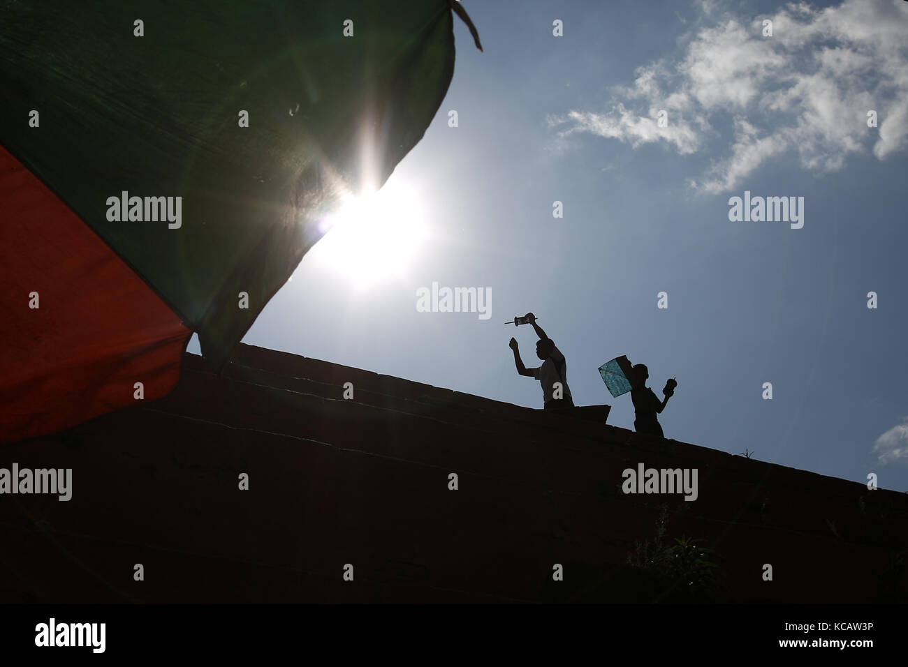 Kathmandu, Nepal. 4 Ott 2017. I ragazzi volano un aquilone come parte delle festività che si avvicinano alla fine del festival di Dashain in cima ad un tempio caduto a Kathmandu, Nepal, mercoledì 04 ottobre 2017. Credit: Skanda Gautam/ZUMA Wire/Alamy Live News Foto Stock