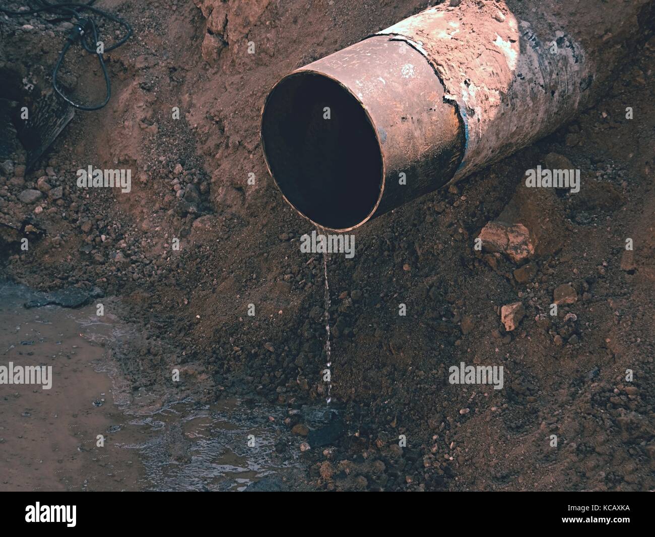 Ferro vecchio arrugginito tubo con acqua chiara che scorre da essa. i  rifiuti tubo di scarico acqua in argilla Foto stock - Alamy