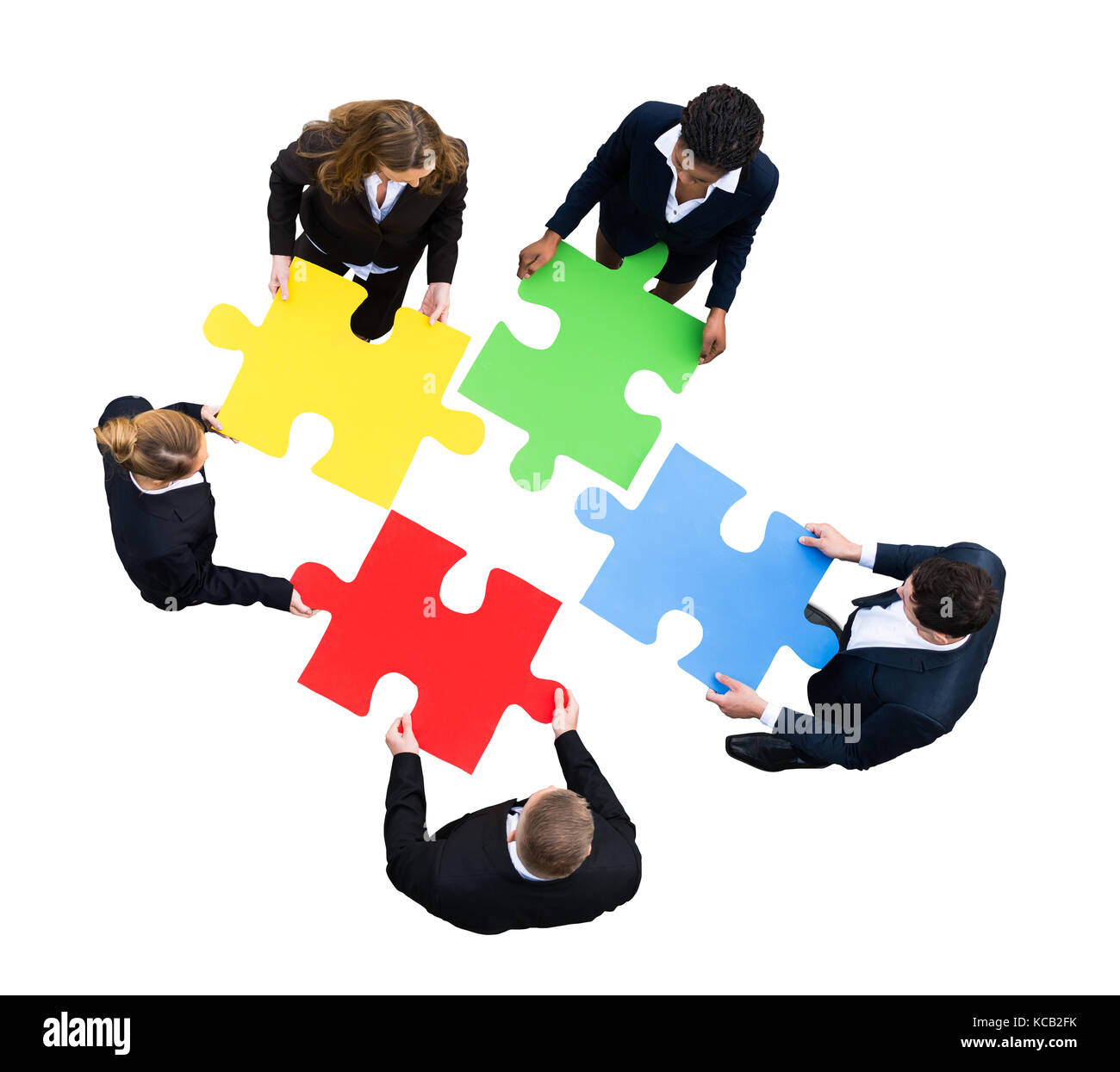 Elevato angolo di visione di un businessman risolvendo puzzle su sfondo bianco Foto Stock